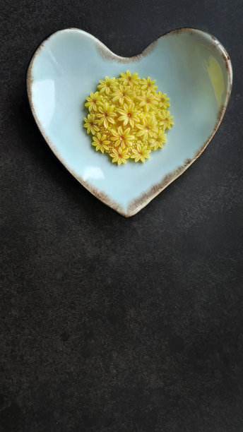 芒果味，颜色黄色，三盘尼传统泰式手工小吃，淡蓝色心形盘，深色背景，垂直图像与复制空间图片下载