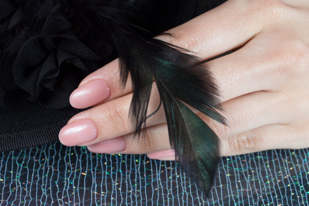 女人的手，漂亮的粉色美甲。钉的设计。图片下载