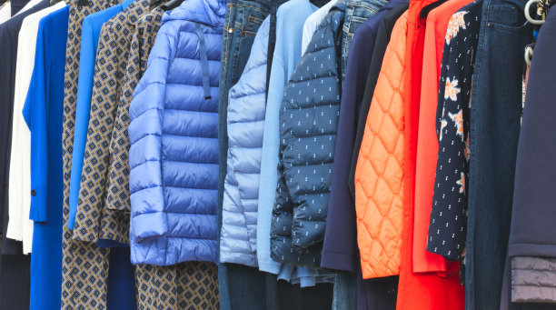 时尚的衣服上的衣服架-鲜艳多彩的衣柜。近距离彩虹色的时尚女装选择在商店衣柜衣架或春季大扫除的概念。夏季家庭衣柜。夹克图片下载