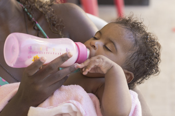 女婴，大约6个月大，睡在高脚椅上的儿童座椅上图片下载