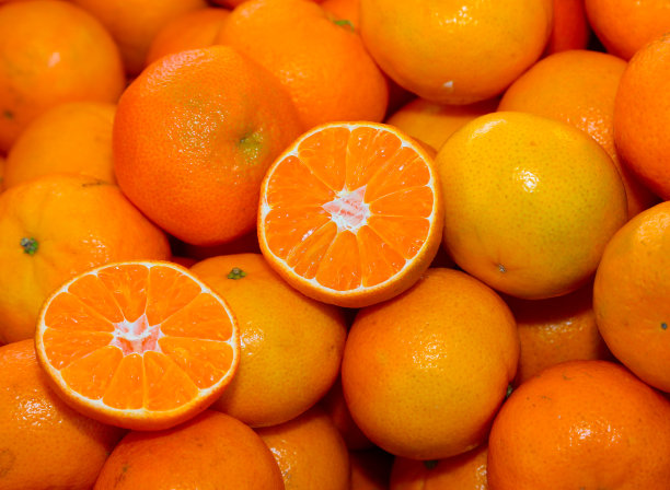 小柑橘或橘子，有些切成两半在蔬菜水果店出售图片下载