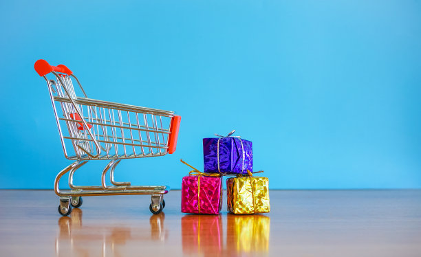 小购物车和礼品盒在蓝色背景与复制空间图片下载