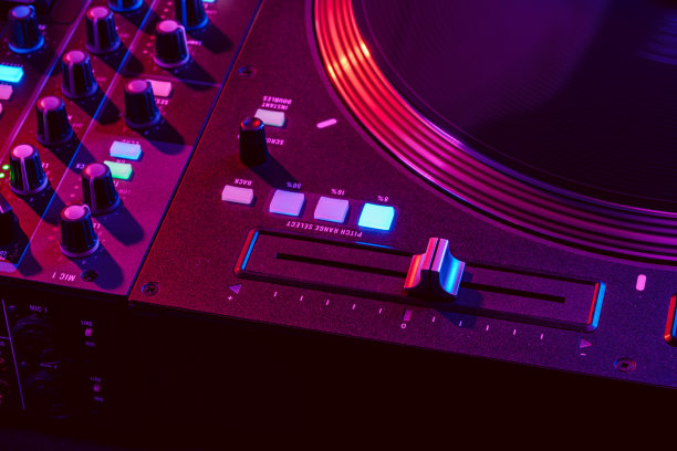 在派对灯光下的DJ混合控制台的特写图片下载