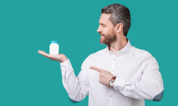 一名男子用手指指着药瓶。照片中的男子手持药物，医疗保健。图片下载