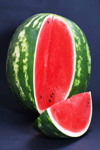 在黑色的背景上切一块又红又熟又美味多汁的西瓜图片下载