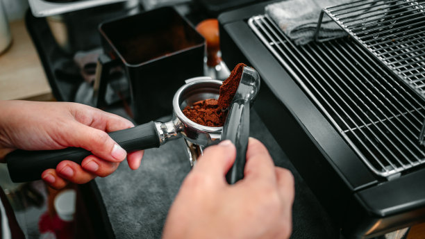 咖啡机的手拿着勺子倒咖啡粉研磨机研磨咖啡倒进过滤器图片下载