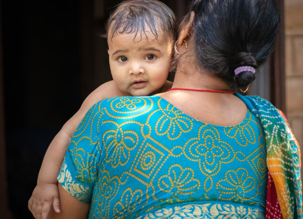 婴儿洗澡后平躺在祖母肩膀上的面部表情图片下载