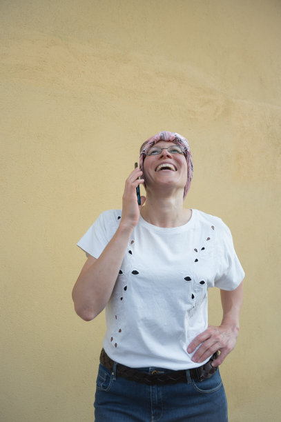 带着癌症头巾的女人，正在愉快地讲电话图片下载