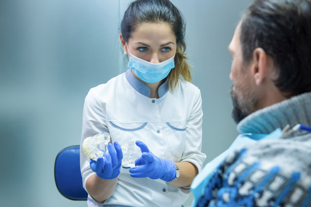 牙医正拿着假牙。图片下载