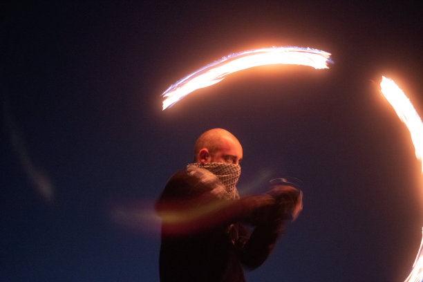 男人在晚上旋转火poi图片下载