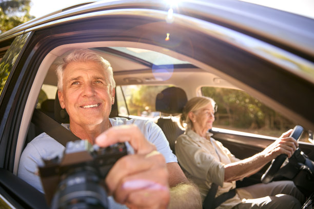 男乘客用相机拍照，老人夫妇在车上享受一日游图片下载
