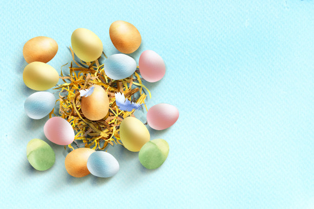 五颜六色的复活节彩蛋在巢里带着羽毛，色彩柔和。快乐复活节概念，横旗，海报，模板标题。手绘水彩插图在蓝色背景图片下载
