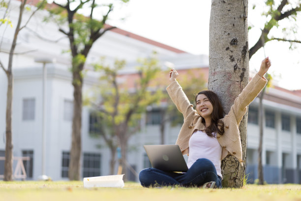 亚洲女学生在大学附近学习备考。通过连接到互联网的手机或笔记本电脑进行交流。知识来源丰富图片下载