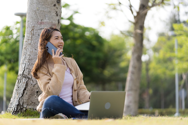 亚洲女学生在大学附近学习备考。通过连接到互联网的手机或笔记本电脑进行交流。知识来源丰富图片下载
