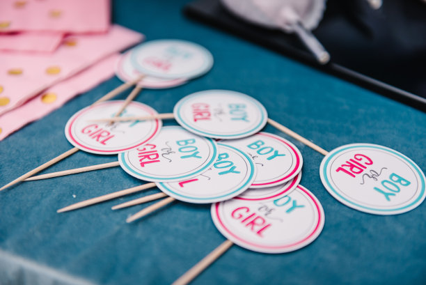 为性别派对设计的粉色和蓝色装饰桌子。用短信男孩或女孩在棍子上签名。婴儿派对装饰。美味的接待。庆祝活动的概念。细节特写镜头。前视图。图片下载