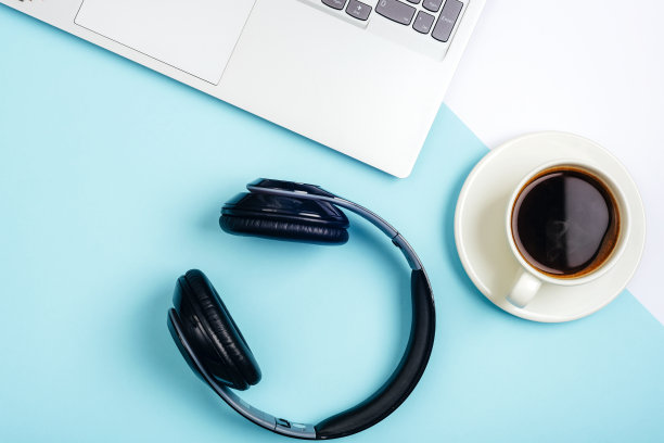 办公桌椅。工作空间，笔记本电脑，办公用品，耳机和咖啡杯在蓝色背景。俯视图，平面布局图片下载