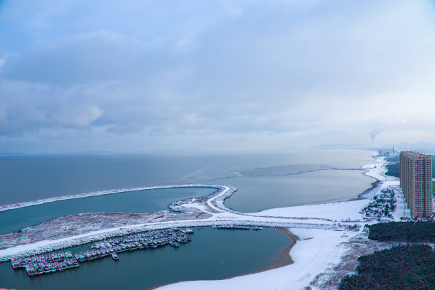 港口的远景。一个繁华的城市坐落在海岸线上。港口停满了船只，被大雪覆盖。图片下载
