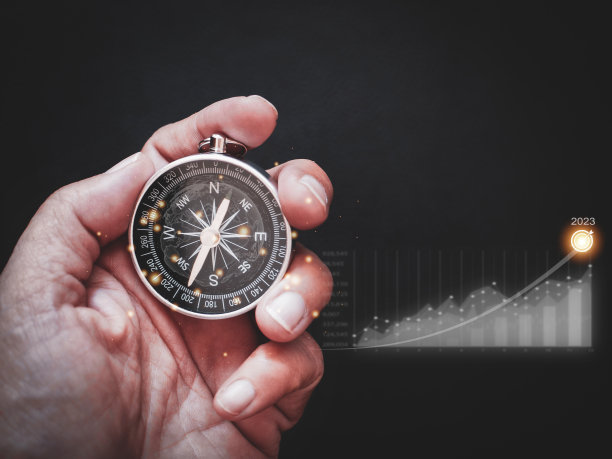 商人拿着指南针，里面有全球图标和显示业务增长的图表，2023年的目标计划图片下载