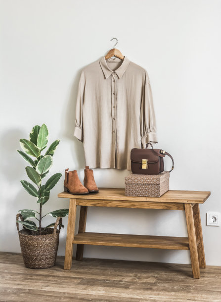 粘胶米色衬衫长袖，绒面革切尔西，斜挎包在更衣室的长凳上图片下载