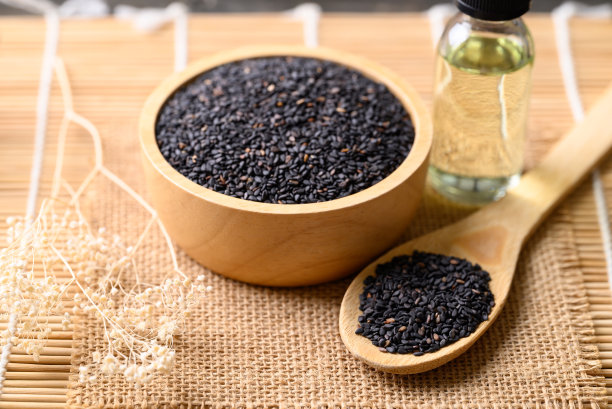 黑芝麻和油在木制背景上，亚洲菜的食材图片下载