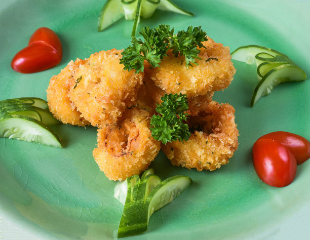 用面糊煎鱿鱼或鱿鱼，放在绿色盘子上，侧视图图片下载