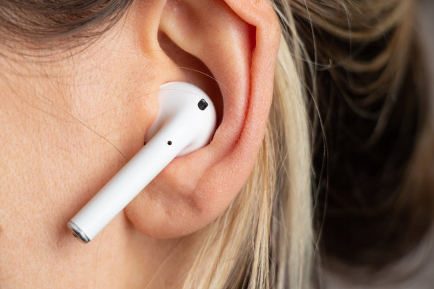 无线白色耳机在一个女孩的耳朵近距离图片下载