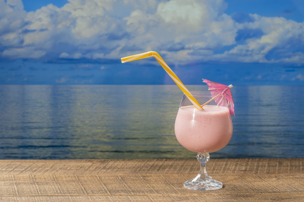 健康的草莓冰沙，在一个阳光明媚的夏日，在木桌上的玻璃酒杯与海水背景，特写，复制空间图片下载