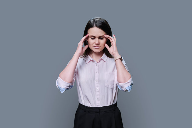 年轻女子患有压力性头痛，背景为灰色图片下载