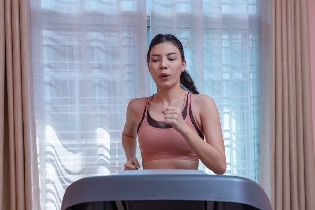 女子在室内跑步机上跑步。图片下载