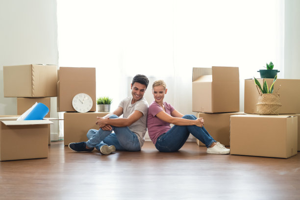 搬到新公寓或新房子。幸福的一对美丽成熟的情侣，穿着休闲的衣服，坐在地板上的纸箱之间。感人的一天。搬家和房地产概念图片下载