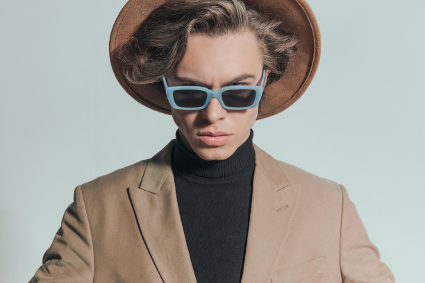 自信的金发男子，戴着帽子和太阳镜图片下载