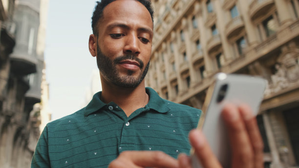 一个年轻人站在路边用手机的特写镜头图片下载