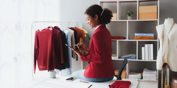 美国非洲裔时装设计师在工作室工作与笔记本电脑图片下载