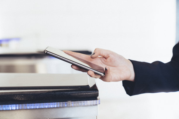 年轻女子在地铁站检票，通过智能手机进行快速简单的非接触式支付。NFC技术，一键即走的概念图片下载