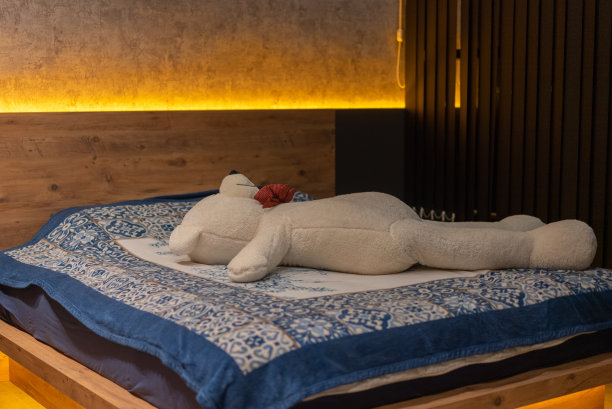 大泰迪熊躺在床上，空的育儿室图片下载