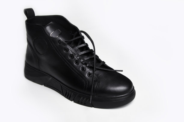 散焦一只黑色皮鞋，白色背景。男士踝靴皮革，白色背景，封闭式。冬季靴子。失焦图片下载