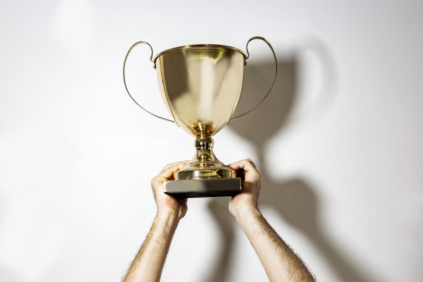 金杯在男子手中的白色背景上孤立，复制空间，文字空间图片下载