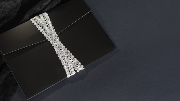 黑色信封模型，从顶部拍摄的黑色背景与复制空间。用银丝带系着。图片下载