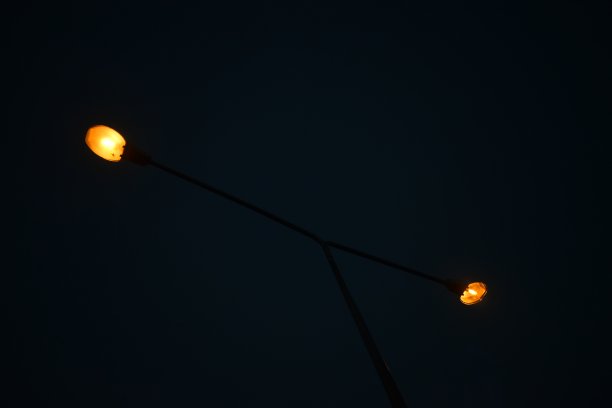 温暖的橙色灯光在夜晚，黑色的天空背景图片下载