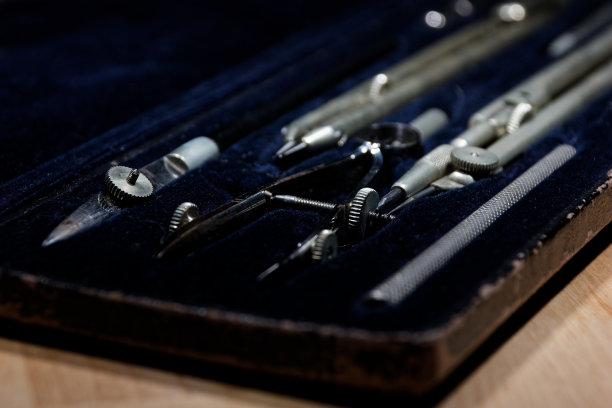 一套分割线，圆规在一个盒子里几何构造躺在木桌上图片下载