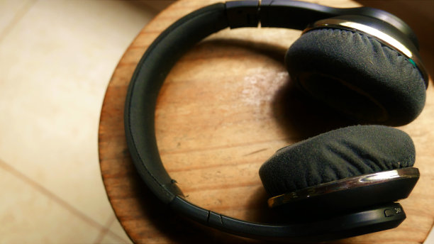 旧的耳机。特写:旧无线耳机。蓝牙耳机放在桌子上。蓝牙耳机。外部耳机图片下载