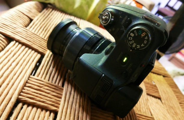 摄影师工作:数码相机在桌子上。相机准备好了。使用相机图片下载