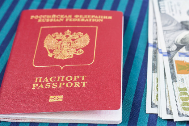 100美元的钞票，放在俄罗斯护照旁边。图片下载