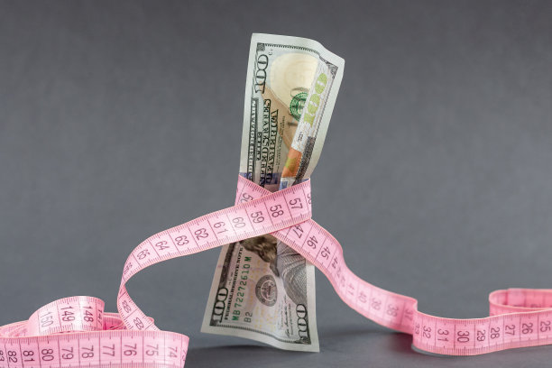 100美元美钞带卷尺。通货膨胀，税收，违约，债务的概念。图片下载