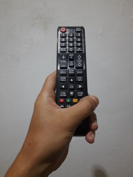 有人的手拿着电视遥控器图片下载