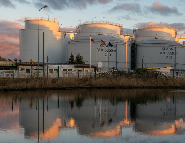 液体燃料储存设施在水中反射镜面图片下载