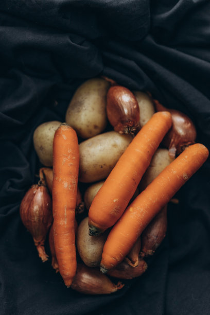 黑色背景的蔬菜:土豆、胡萝卜和洋葱图片下载