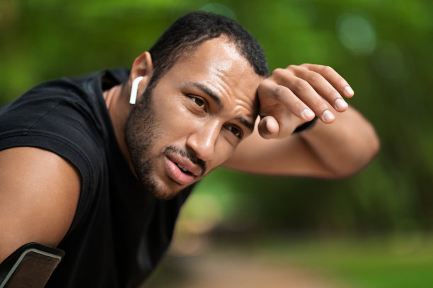 特写肖像疲惫的年轻黑人男子慢跑在公园图片下载