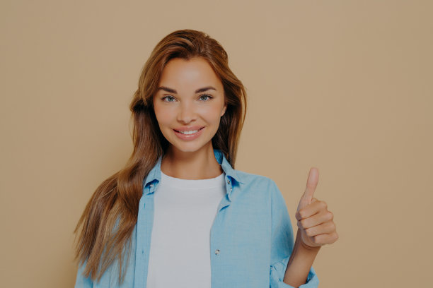 腰部向上的镜头，满意的支持妇女显示拇指向上图片下载