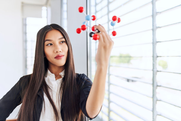 创新的概念。亚洲女商人在现代办公室看分子模型图片下载
